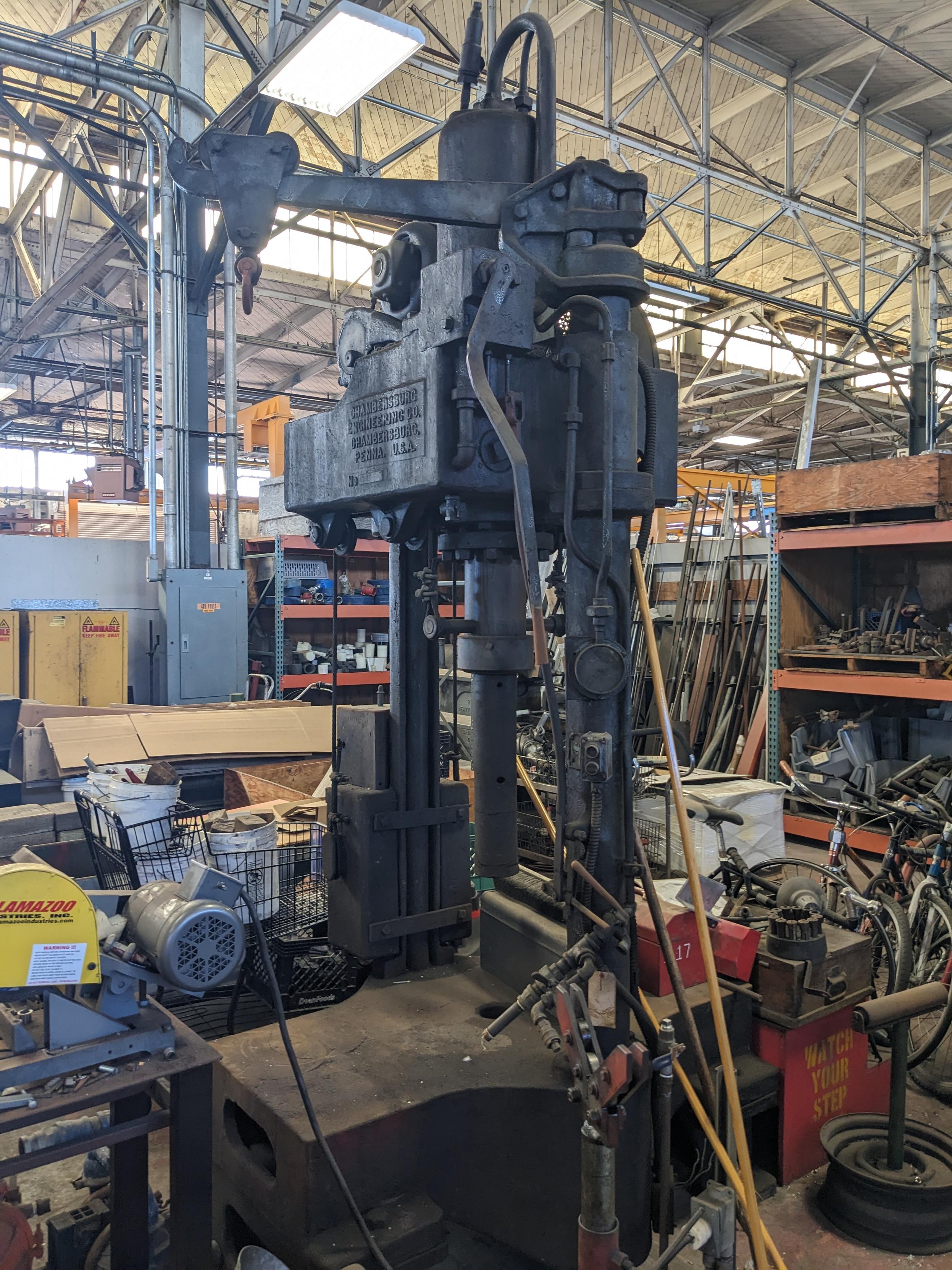 Large old black press in a cluttered machine shop